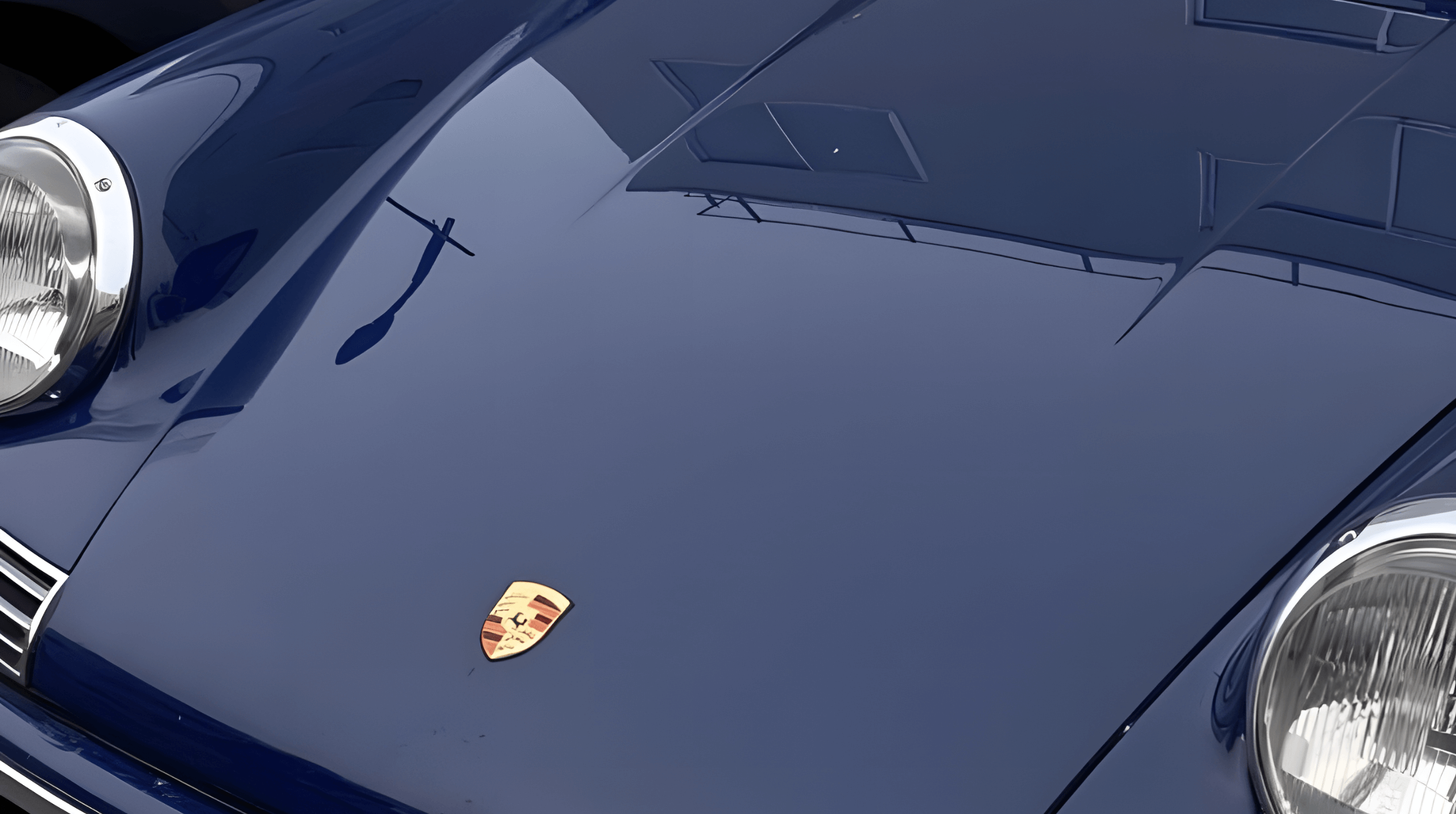 Close-up of a navy blue Porsche bonnet with chrome details